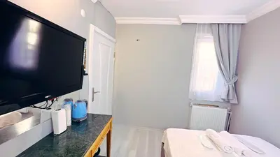 a bedroom with a flat screen tv and a bed at Taksim Centre Hotel in Istanbul