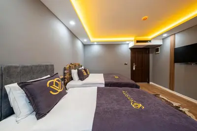 a bedroom with two beds and a flat screen tv at Viv City Hotel in Istanbul