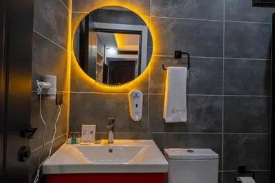 a bathroom with a sink and a mirror and a toilet at Viv City Hotel in Istanbul
