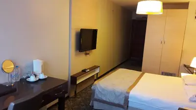 a hotel room with a bed and a flat screen tv at Derpa Suite Hotel in Istanbul