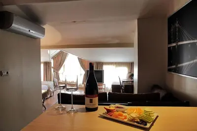 a bottle of wine and a plate of fruit on a table at Derpa Suite Hotel in Istanbul