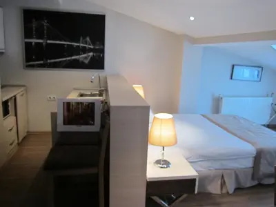 a bedroom with a bed and a desk with a lamp at Derpa Suite Hotel in Istanbul