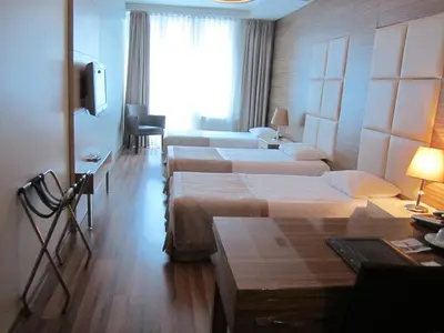 a hotel room with four beds and a television at Derpa Suite Hotel in Istanbul
