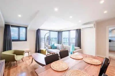 a living room with a table and chairs at Homie Suites - Newly Built Seaside Apartments on Bakırköy Shore in Istanbul