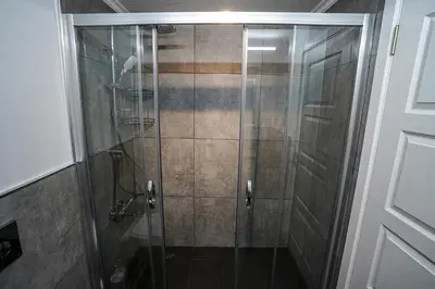 a shower with a glass door in a bathroom at Merkuri apartments in Istanbul