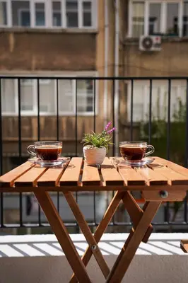 a wooden table with two cups and a plant on it at Merkuri apartments in Istanbul