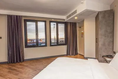 a bedroom with a bed and large windows at GRANDROYAL HOTEL in Gümüşyaka