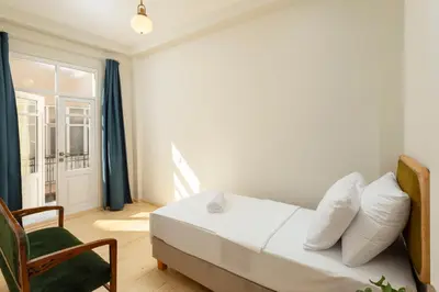 a bedroom with a bed and a chair and a window at Lemon Apartments in Istanbul