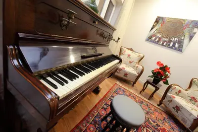 an old piano in a living room with a chair at Lir Residence Suites LONG STAY in Istanbul