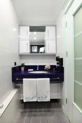 a bathroom with a blue sink and white cabinets at Lir Residence Suites LONG STAY in Istanbul