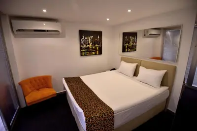 a bedroom with a bed and an orange chair at BGuest Hotel & Residence in Istanbul