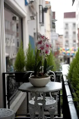 a table with a flower in a bowl on a balcony at BGuest Hotel & Residence in Istanbul
