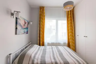 a small bedroom with a bed and yellow curtains at Bright 3BR Apartment Near Kadıköy Seaside in Istanbul