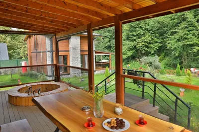 a large deck with a wooden table and a tub at Lal Hayal Konakları in Sakarya
