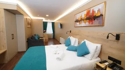 a hotel room with a bed with blue and white pillows at The Marist Hotel Kadikoy in Istanbul