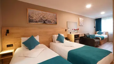 a hotel room with two beds and a living room at The Marist Hotel Kadikoy in Istanbul