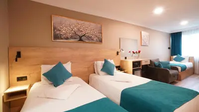 a hotel room with two beds and a living room at The Marist Hotel Kadikoy in Istanbul