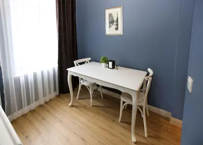 a white table and chairs in a room with a blue wall at Selvese Suites, Serviced Living in Galata in Istanbul