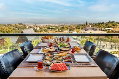 a table with food on top of a balcony at Aronia Bungalow in Elmalık