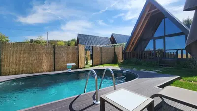 a swimming pool in a backyard with a wooden fence at Aronia Bungalow in Elmalık