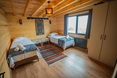 a bedroom with two beds in a wooden cabin at Aronia Bungalow in Elmalık