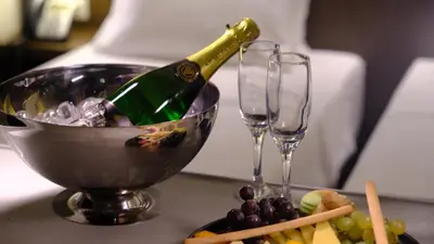 a bottle of champagne in a bowl next to two wine glasses at FEZ INN Hotel in Istanbul
