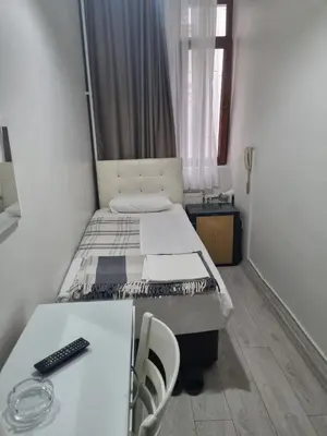 a small room with a bed and a desk and a table at Hotel Hoyuk in Istanbul