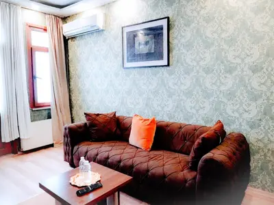 a living room with a brown leather couch and a table at Family apartment in Istanbul