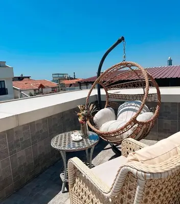 a patio with two chairs and a table on a balcony at Monezza Maltepe Rezidans in Istanbul
