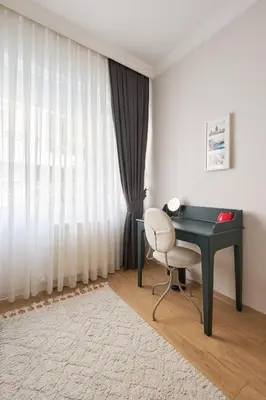 a desk and a chair in a room with a window at Cozy Oasis in Moda Steps to Seafront in Istanbul