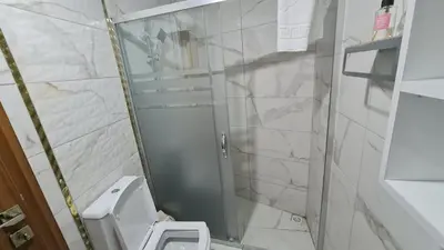 a small bathroom with a toilet and a shower at Cozy 2 bedroom near Green Mosque in Yıldırım