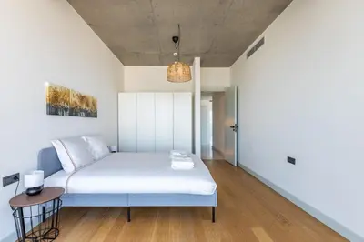a small bedroom with a bed and a table at Beautiful Bright Deluxe 1BD Condo PoolViews! #311 in Istanbul