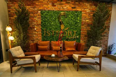 a living room with a couch and chairs and a brick wall at İSTPORT GARDEN HOTELS in Arnavutköy