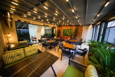 a restaurant with couches and tables and chairs at İSTPORT GARDEN HOTELS in Arnavutköy