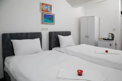two white beds in a room with a red candle on top at Noya Suites in Istanbul