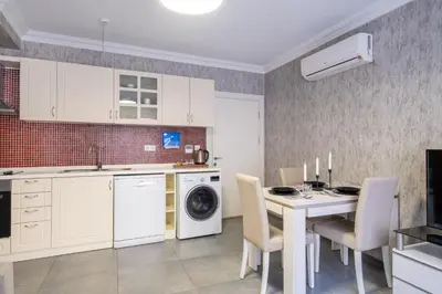 a kitchen with a table and a washing machine at The Canka Residence And Family Apartment Istanbul City Center - ŞIŞLI in Istanbul