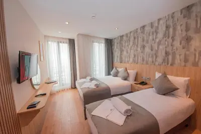 a hotel room with two beds and a television at Mahya Hotel in Istanbul