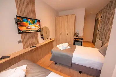 a hotel room with two beds and a flat screen tv at Mahya Hotel in Istanbul
