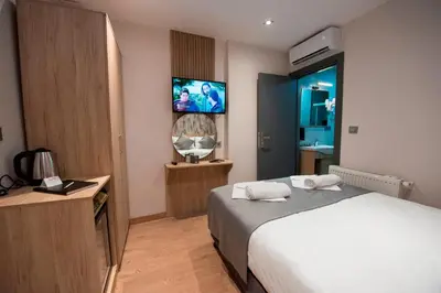a hotel room with a bed and a flat screen tv at Mahya Hotel in Istanbul