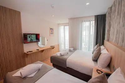 a hotel room with two beds and a television at Mahya Hotel in Istanbul