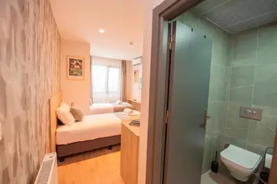 a small bathroom with a bed and a shower at Mahya Hotel in Istanbul