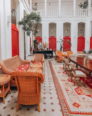 a lobby with chairs and a table and a piano at Büyükada Splendid Palace Hotel in Buyukada