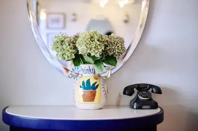 a vase with flowers on a table in front of a mirror at Büyükada Splendid Palace Hotel in Buyukada