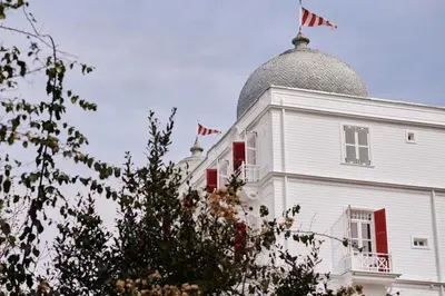 a white building with an american flag on top of it at Büyükada Splendid Palace Hotel in Buyukada