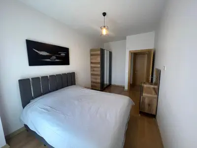 a bedroom with a white bed and a wooden floor at Central Location Free WIFI AC Parking Garage in Esenyurt