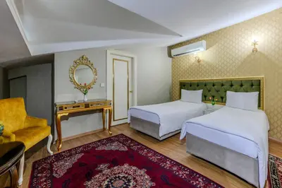 a hotel room with two beds and a mirror at Lemis Suite Istanbul in Istanbul