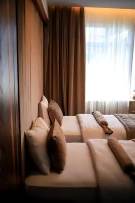 a hotel room with three beds with pillows and a window at THE PARK HOTEL in Istanbul