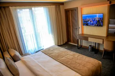 a bedroom with a bed and a desk and a television at THE PARK HOTEL in Istanbul