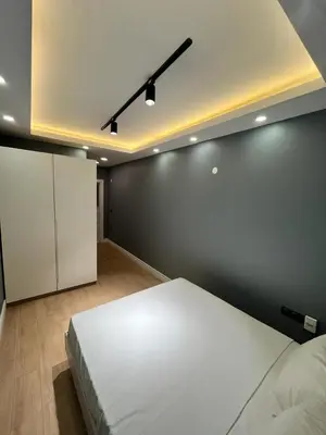 a bedroom with a large white bed and a black wall at Serim Residence in Kocaeli