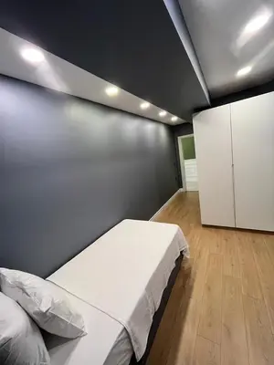 a bedroom with a white bed and a wall at Serim Residence in Kocaeli